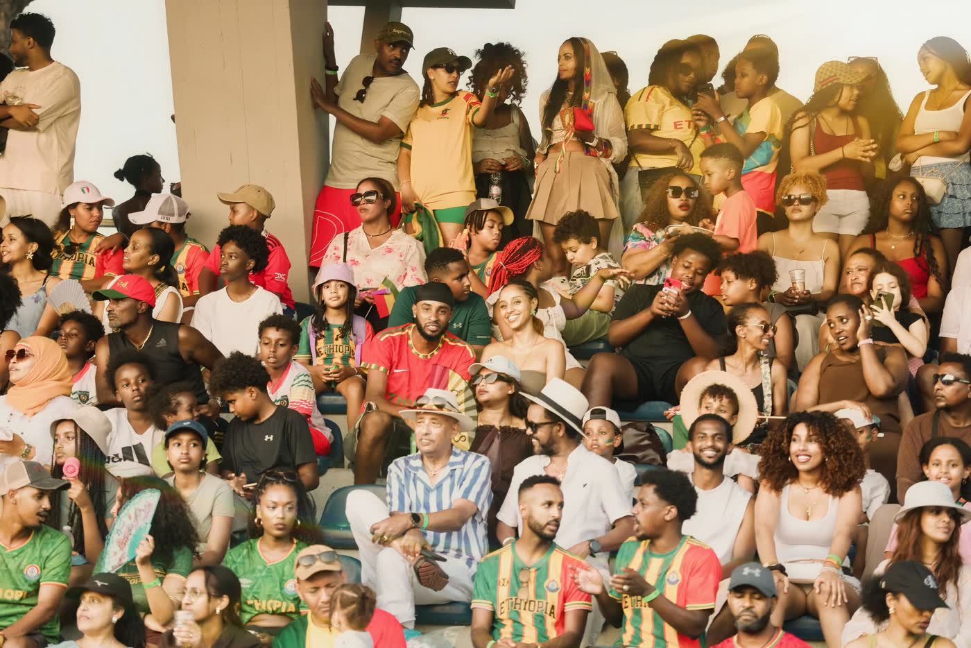 Packed stadium stands at an ESCFE tournament — hundreds of Ethiopian diaspora families, many in Ethiopia football shirts, watching together